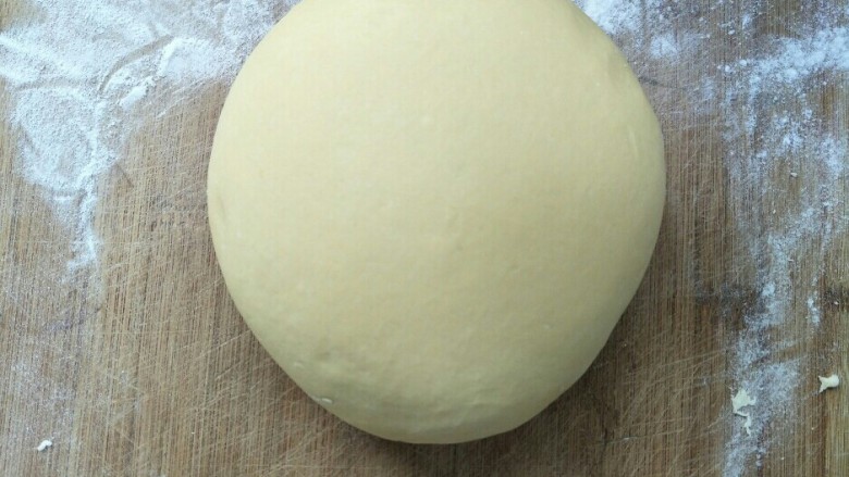 南瓜馒头,发酵好的面团放在面板上揉光排气。