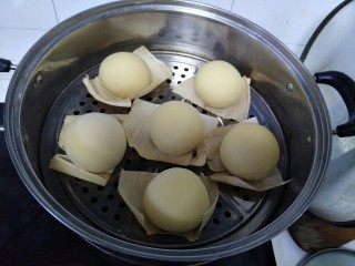 南瓜馒头,揉好的馒头铺上玉米叶子，放在蒸锅中盖上锅盖等待二次发酵。