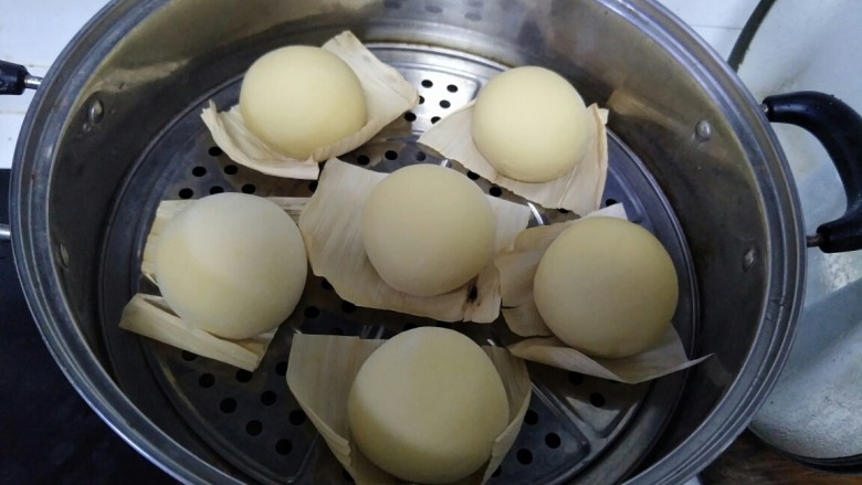 南瓜馒头,揉好的馒头铺上玉米叶子，放在蒸锅中盖上锅盖等待二次发酵。