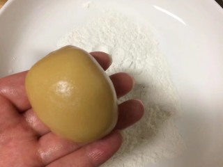 #甜味#莲蓉蛋黄月饼,搓成一个鸡蛋状，这样有利于放入模具中，在炒熟的粘米粉中裹薄薄的一层米粉，不可太多