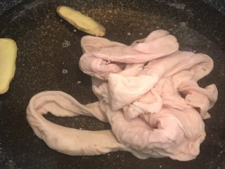 火爆猪大肠,清洗好的大肠放在锅里，加入姜片和料酒，煮大概半小时；