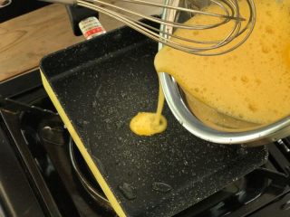 芝士鸡蛋卷,将打好的鸡蛋缓慢倒入锅内，上下左右晃动铺满整个锅面