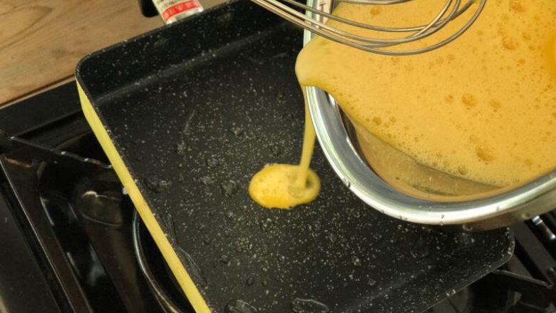 芝士鸡蛋卷,将打好的鸡蛋缓慢倒入锅内，上下左右晃动铺满整个锅面