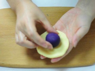 小猪卡通月饼,黄色面团按成饼，放入紫薯馅