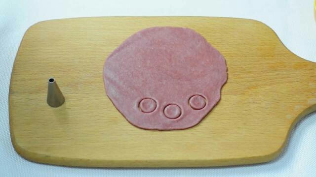 小猪卡通月饼,红色面团擀成饼，用裱花嘴压出耳朵和鼻子