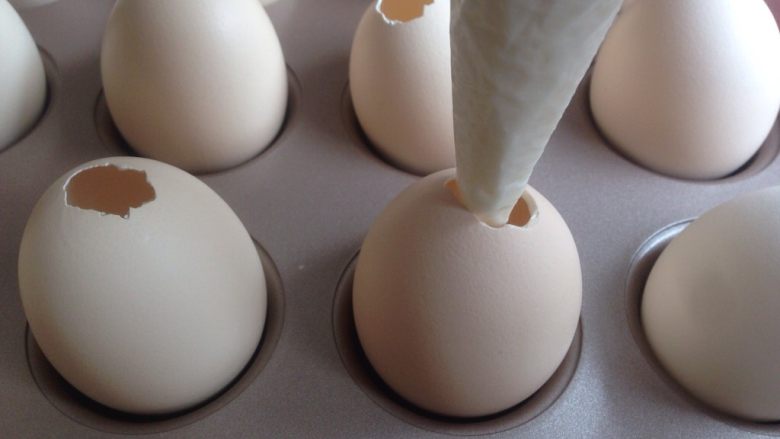 鸡蛋壳蛋糕,将蛋糕糊挤进蛋壳里，装5、6分满可以了。蛋壳可以架在12连小蛋糕模里，是刚刚好的