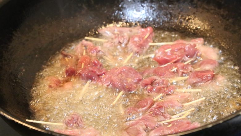 牙签牛肉,锅里多放一些油，烧热后放入串好的牛肉。