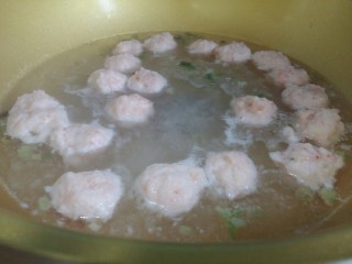 虾丸菠菜汤,把腌制好的虾泥挤出丸子。在虎口处挤出丸子，用勺子挖下来放入锅中。