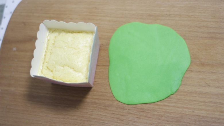 零基础纸杯翻糖蛋糕,玩儿翻糖手一定要保持特别干净，沾上点食用油取一小块绿色糖皮，擀成比蛋糕平面大一点的薄皮。特别注意，一旦感觉糖皮粘手就站点植物油。