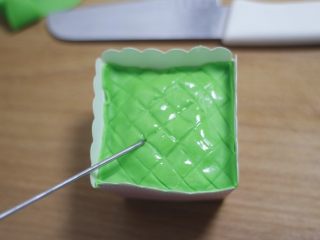 零基础纸杯翻糖蛋糕,压好格子的糖皮覆盖在蛋糕上面，点两滴植物油润一下表面，不明显的网格线在用工具压深一点。
