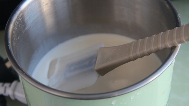 巧克力牛奶双色布丁,冷藏的同时，把剩下的一半淡奶油和牛奶倒入奶锅