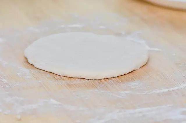 最简单的饼，最经典的味——葱油饼,取擀面杖一根，把面团擀成差不多1厘米厚的面皮。