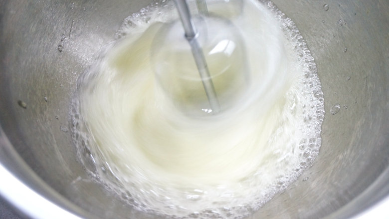韩式豆沙裱花戚风蛋糕,60克白糖分三次放入蛋白糊中，第一次，用电动打蛋器中速将蛋清打出粗泡；