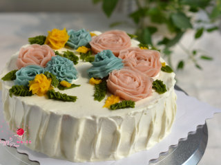韩式豆沙裱花戚风蛋糕,将各种花朵转移到蛋糕上，再挤出花叶来装饰。