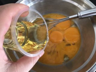 红丝绒戚风（8寸方子）,蛋黄蛋清分别分离在2个干净无水无油的盘子里
蛋黄盘里加入玉米油