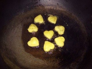 爱心土豆饼,﻿锅里倒入油，烧成七八成热﻿﻿﻿，倒入爱心土豆饼，小火油炸﻿﻿﻿，炸至黄色，翻面，炸好后，捞出控油﻿﻿﻿