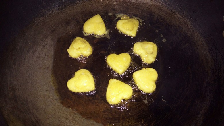 爱心土豆饼,﻿锅里倒入油，烧成七八成热﻿﻿﻿，倒入爱心土豆饼，小火油炸﻿﻿﻿，炸至黄色，翻面，炸好后，捞出控油﻿﻿﻿