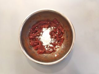 孜然牙签牛肉,腌制完成后，可以看到碗底的水已经完全被肉吸收了，然后加入10g淀粉，搅拌均匀；