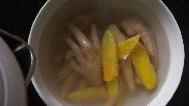 柠香泡椒凤爪,煮好的鸡爪放入大碗里，其他配料都不要留下生姜，倒入凉白开没过鸡爪浸泡一下。