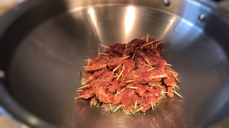 孜然牙签牛肉,牙签肉下锅，先不着急翻动，待闻到肉香味，底部的肉成熟时在翻炒；