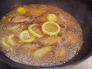 柠檬鸡翅,大火煮开后，放入柠檬片混合。盖上锅盖，转小火。