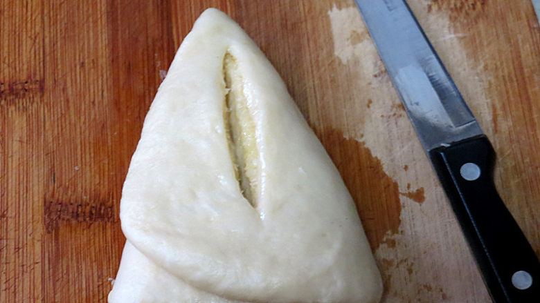 椰香味浓滴【椰蓉叶子面包】,用抹了油的小刀在当中切一刀，注意别切断两头