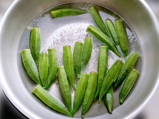 绿色美食凉拌秋葵,锅中沸水，放入秋葵水焯2分钟