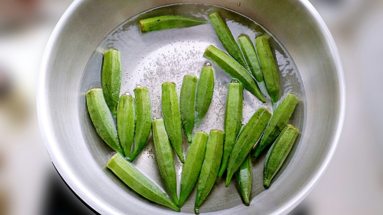 绿色美食凉拌秋葵,锅中沸水，放入秋葵水焯2分钟