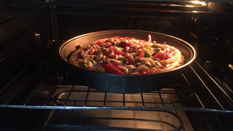 意式鲜虾烟熏香肠披萨,放入烤箱中层，上下火200度，烤15分钟。