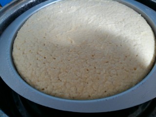 玉米面发糕,发酵好的玉米面糊已经满模了。上面刷一层菜籽油。（刷油的目的是防止蒸的时候锅盖上的水滴进去发糕内部，而影响口感。）