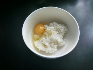 剩米饼,先打入一个鸡蛋至米饭中。