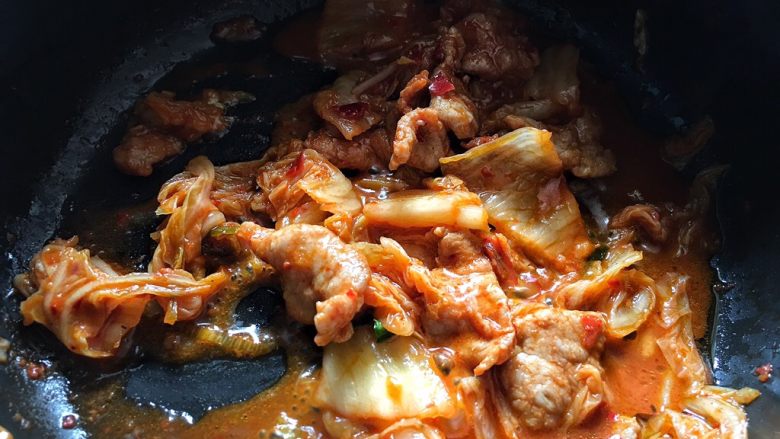 酸辣暖胃的 辣白菜豆腐锅,加入腌好的肉片，翻炒一会