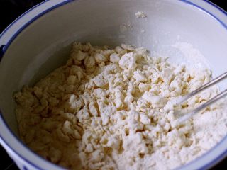 发面芝麻碱饼,先用筷子慢慢搅拌面粉、酵母水要一点一点加入