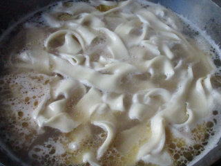 牛骨汤烩面,把和好 的面胚拉长后从压痕处分成两根，入锅煮熟