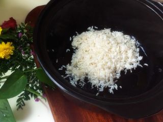 腊味双拼煲仔饭,将泡好的大米放入砂锅中