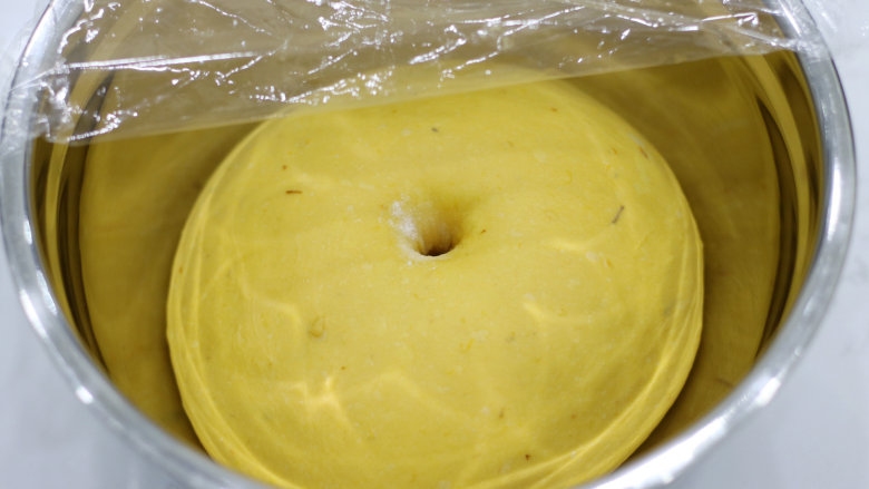 丰收的季节——金色南瓜吐司, 覆盖保鲜膜，放入发酵箱中，温度设置为26℃，进行一发。手指沾面粉戳一下面团，略有回缩最后呈肚脐状即可。