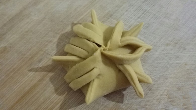 兰花蒸饺,﻿5个折都剪好﻿，第1个折的第1条和第2个折的第2条对着捏拢﻿﻿﻿