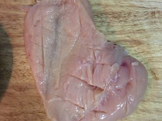 剁椒蒸土豆鸡胸,接着在鸡胸的两面都划出刀痕，方便入味，并用少许盐均云抹在两面的肉上。