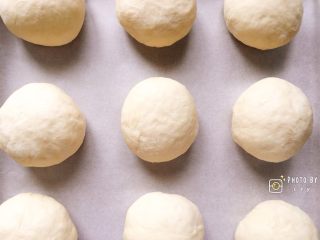 会拉丝的火腿芝士熔岩面包,依次摆放在铺好油纸的烤盘上，烤箱35度二次发酵半小时。