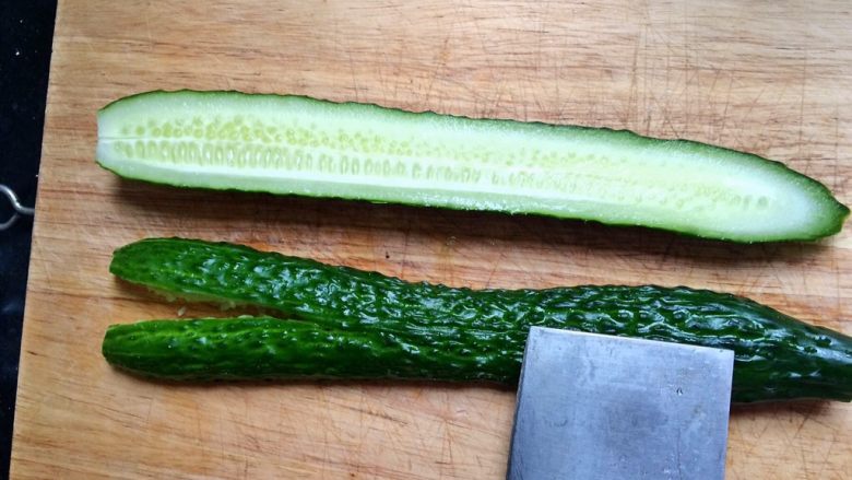 ＃绿色美食＃开胃菜凉拌黄瓜,冼净的黄瓜对半切开，用刀背拍碎。