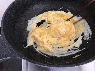 绿色美食～苦瓜炒蛋,蛋液开始凝固时，筷子顺一方向打圈，直到全部凝固（这样炒出来的蛋花比较蓬松饱满有弹性哟）
