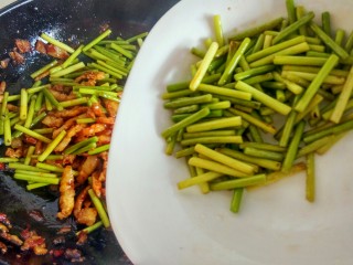绿色美食＋蒜苔炒肉丝,倒入蒜苔，继续翻炒。