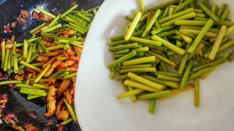 绿色美食＋蒜苔炒肉丝,倒入蒜苔，继续翻炒。