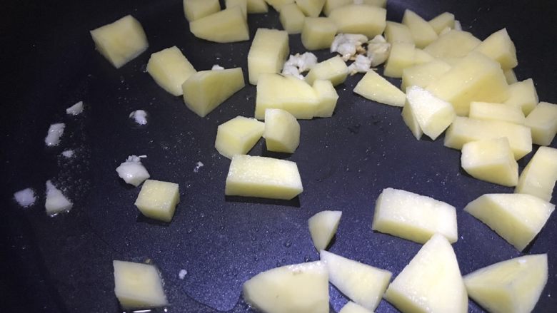 红腐乳焖土豆,倒入土豆翻炒至金黄色
