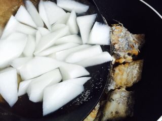 白萝卜带鱼汤,把白萝卜倒入煎带鱼的锅内