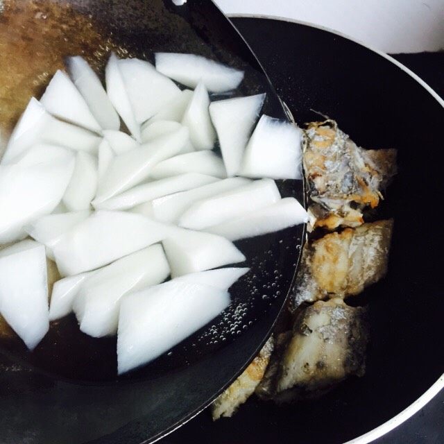 白萝卜带鱼汤,把白萝卜倒入煎带鱼的锅内