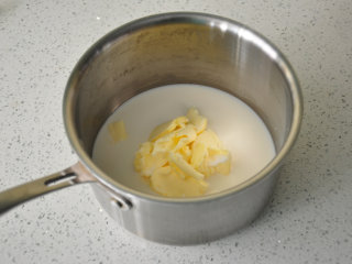 西班牙油条——吉拿果,锅内倒入牛奶、无盐黄油、细砂糖和盐。