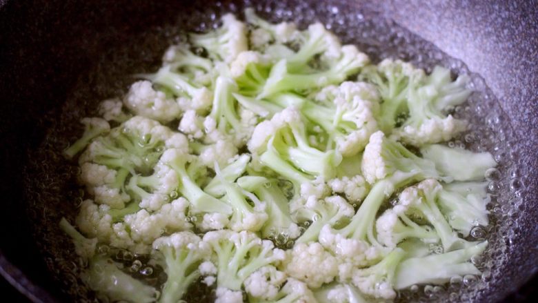 绿色美食+酱爆菜花,锅中加入适量水烧开、将菜花洗净焯水