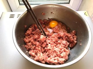 白菜猪肉水煎包,接着准备肉馅，放一个鸡蛋搅拌均匀