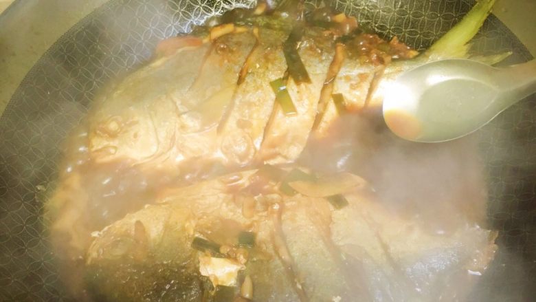 红烧鲳鱼,期间用勺子把汤汁淋在鱼身上数次，并尝汤汁味道，不够哪里及时调整。